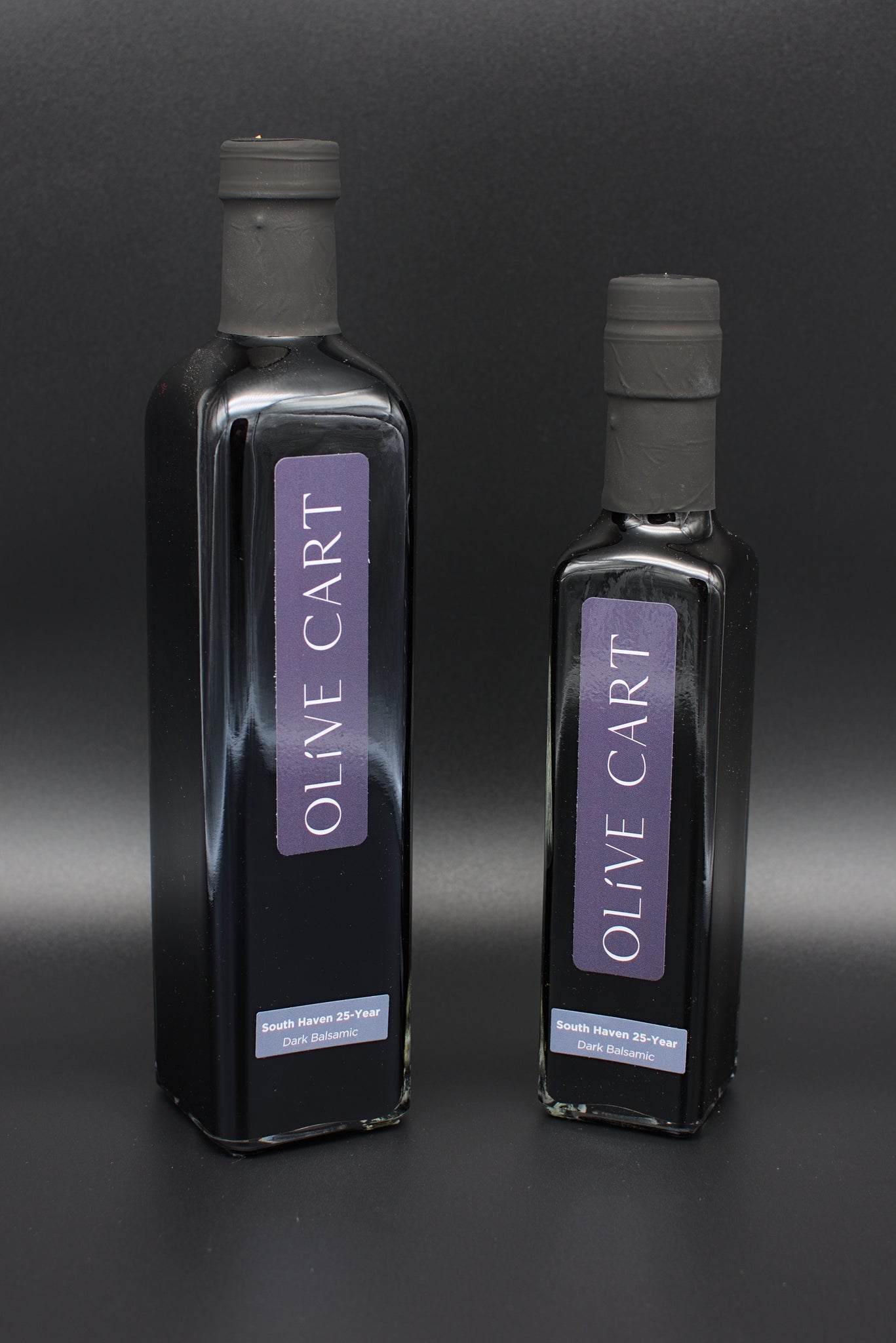 Two different sized bottles of Olive Cart's Chocolate Marshmallow balsamic in front of wood board