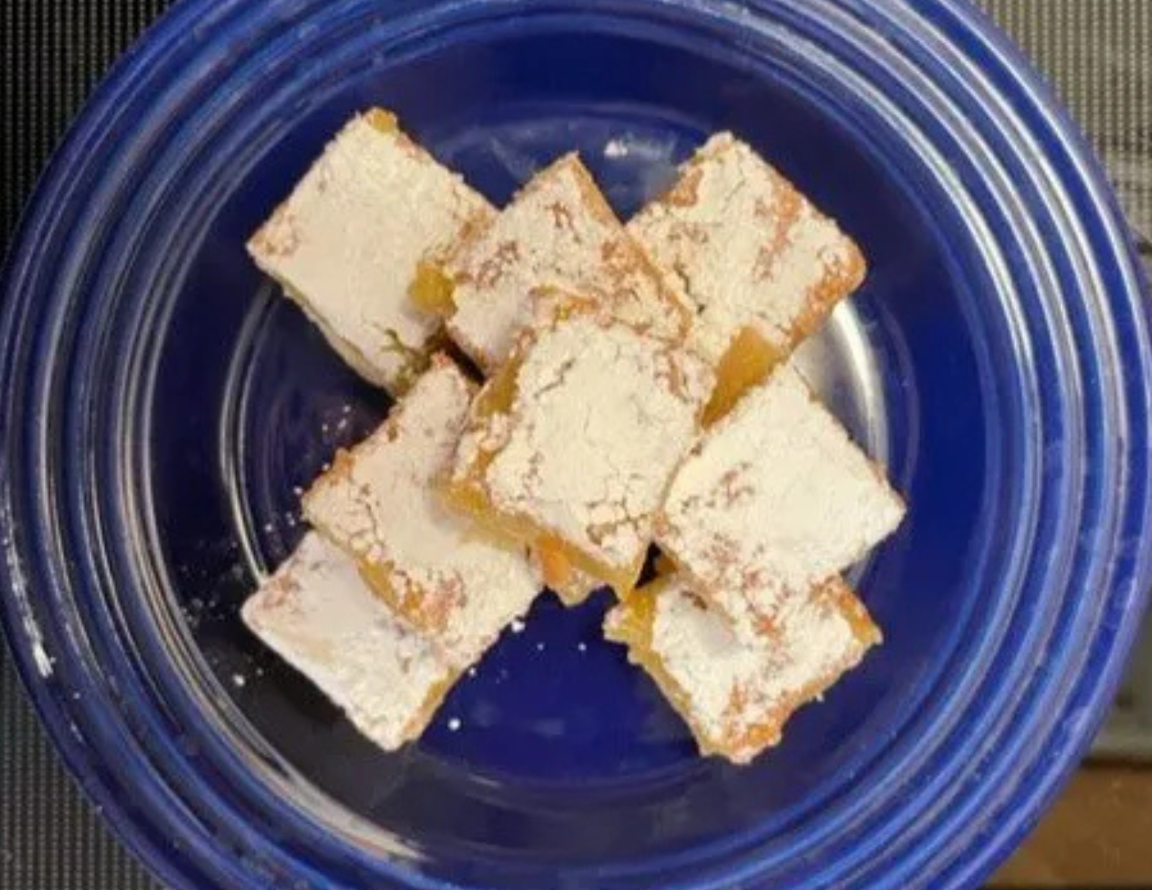 Square lemon raspberry bars on a blue plate